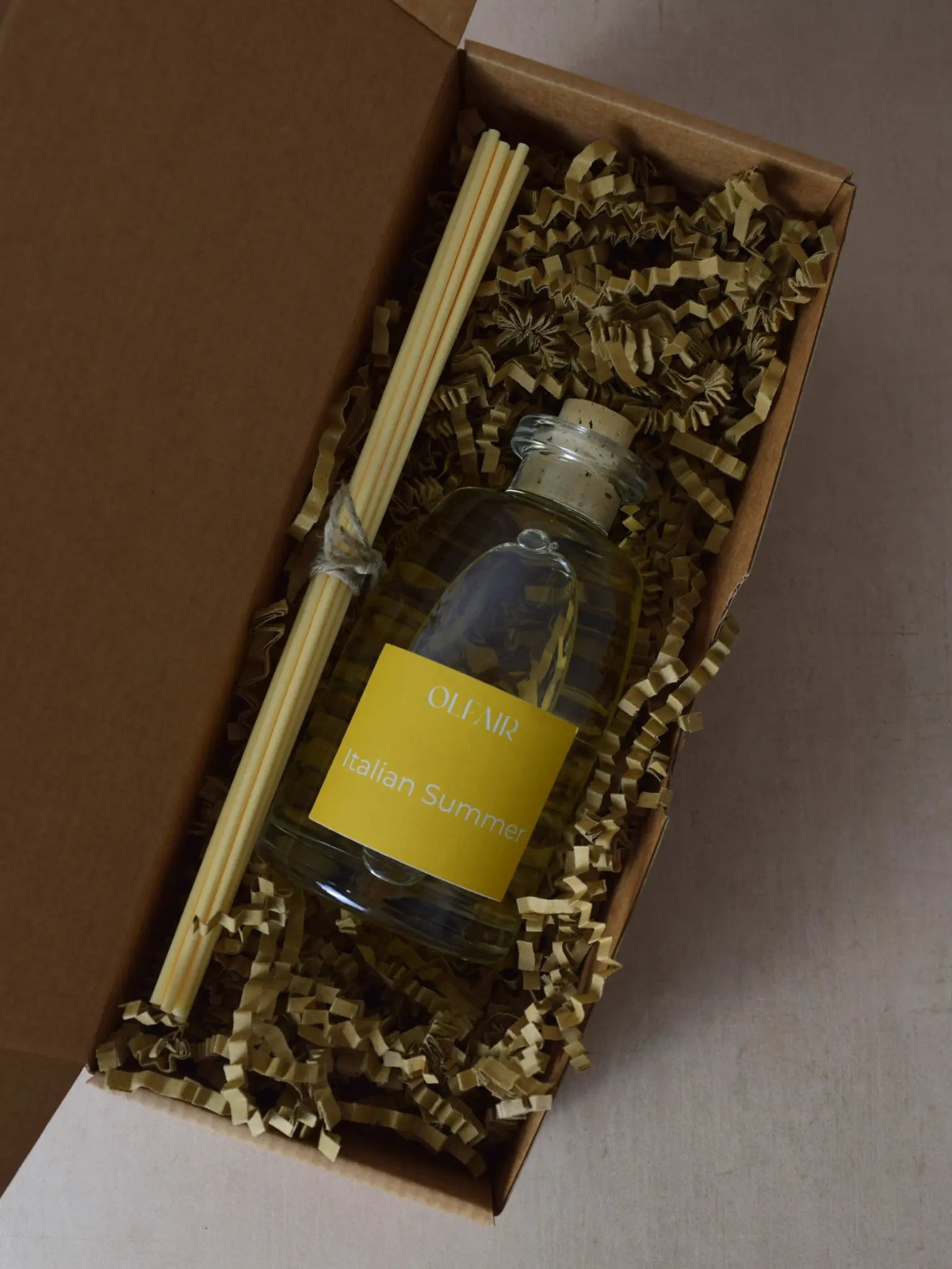 Raumduft mit gelber Etikette mit Stäbchen in einer Box.