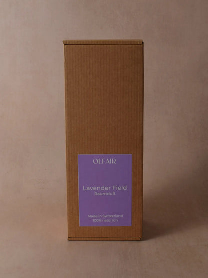 Kartonbox für Raumduft mit violettem Etikett vor einem beigen Hintergrund.