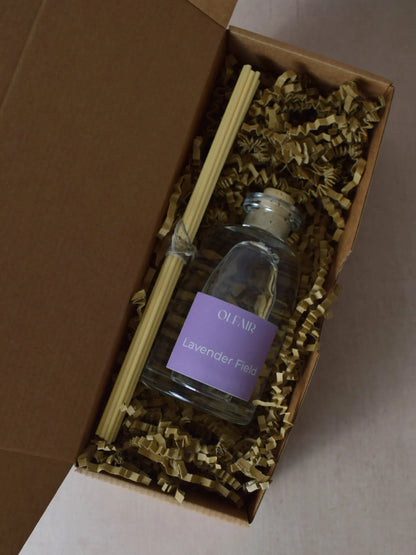 Raumduft mit violettem Etikette mit Stäbchen in einer Box.