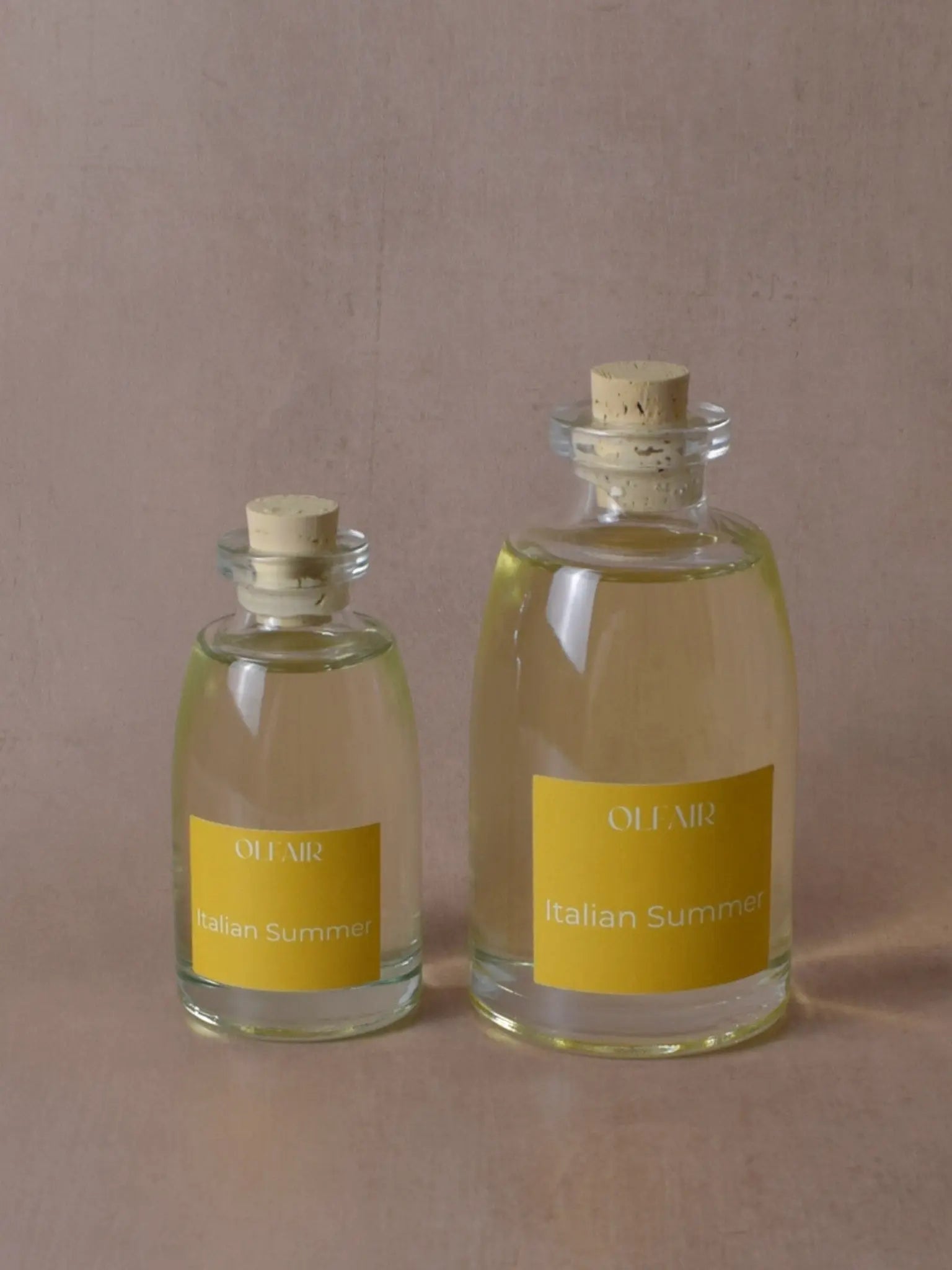 Kleiner und grosser Raumduft mit gelber Etikette vor einem beigen Hintergrund.