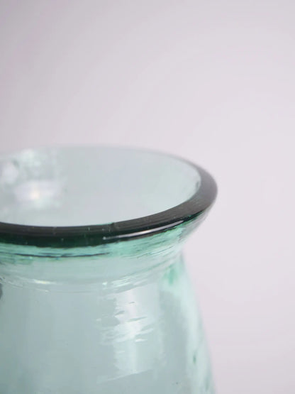 Nahaufnahme einer bläulichen Vase vor einem weissen Hintergrund