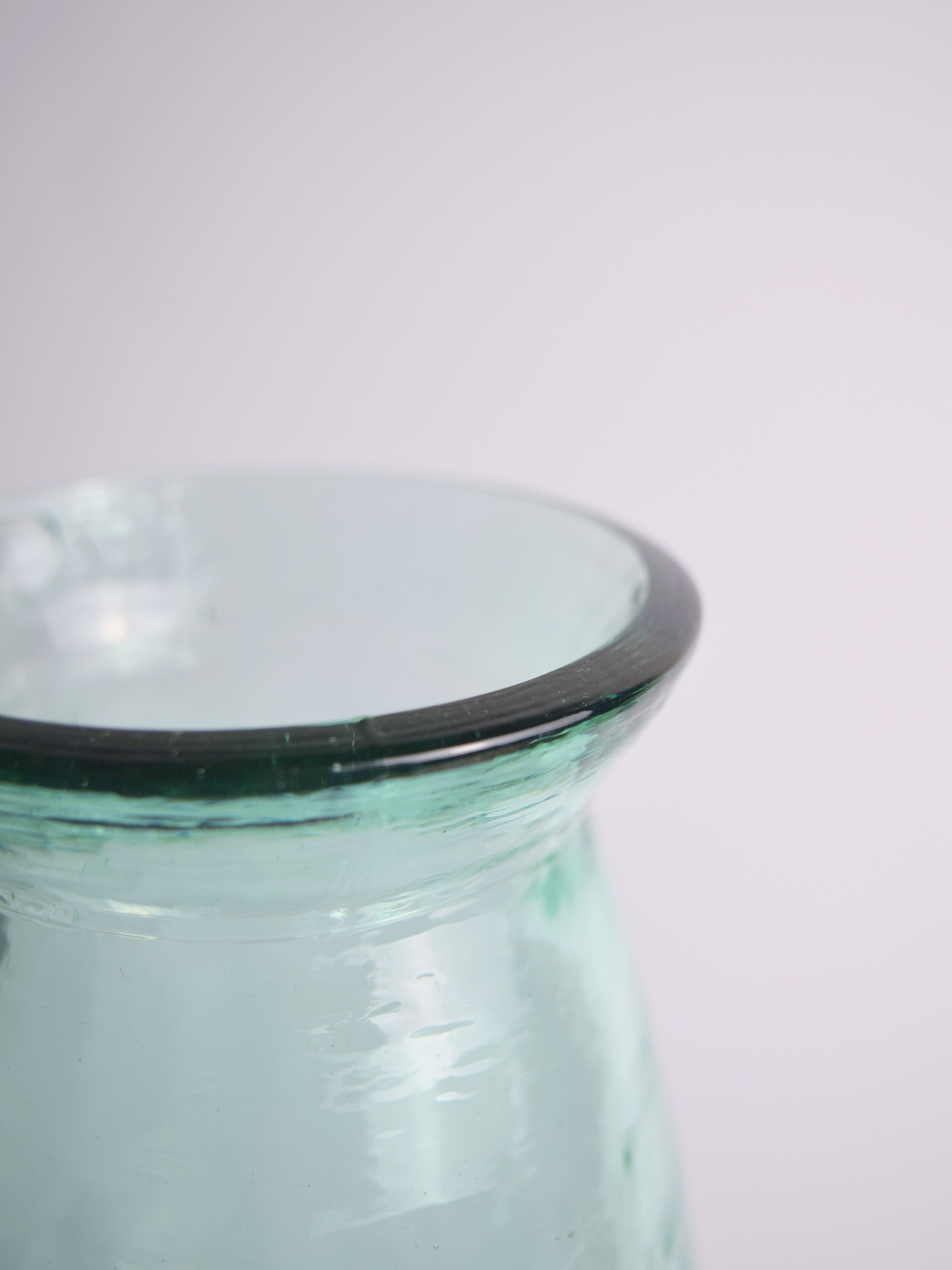 Nahaufnahme einer bläulichen Vase vor einem weissen Hintergrund