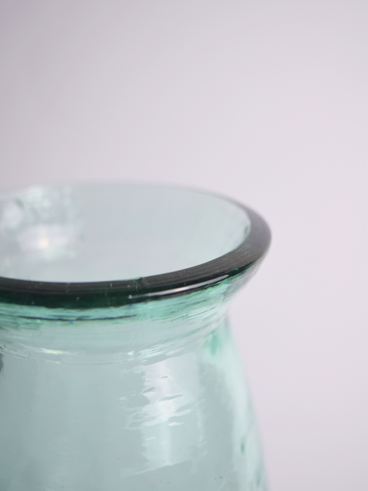 Nahaufnahme einer bläulichen Vase vor einem weissen Hintergrund