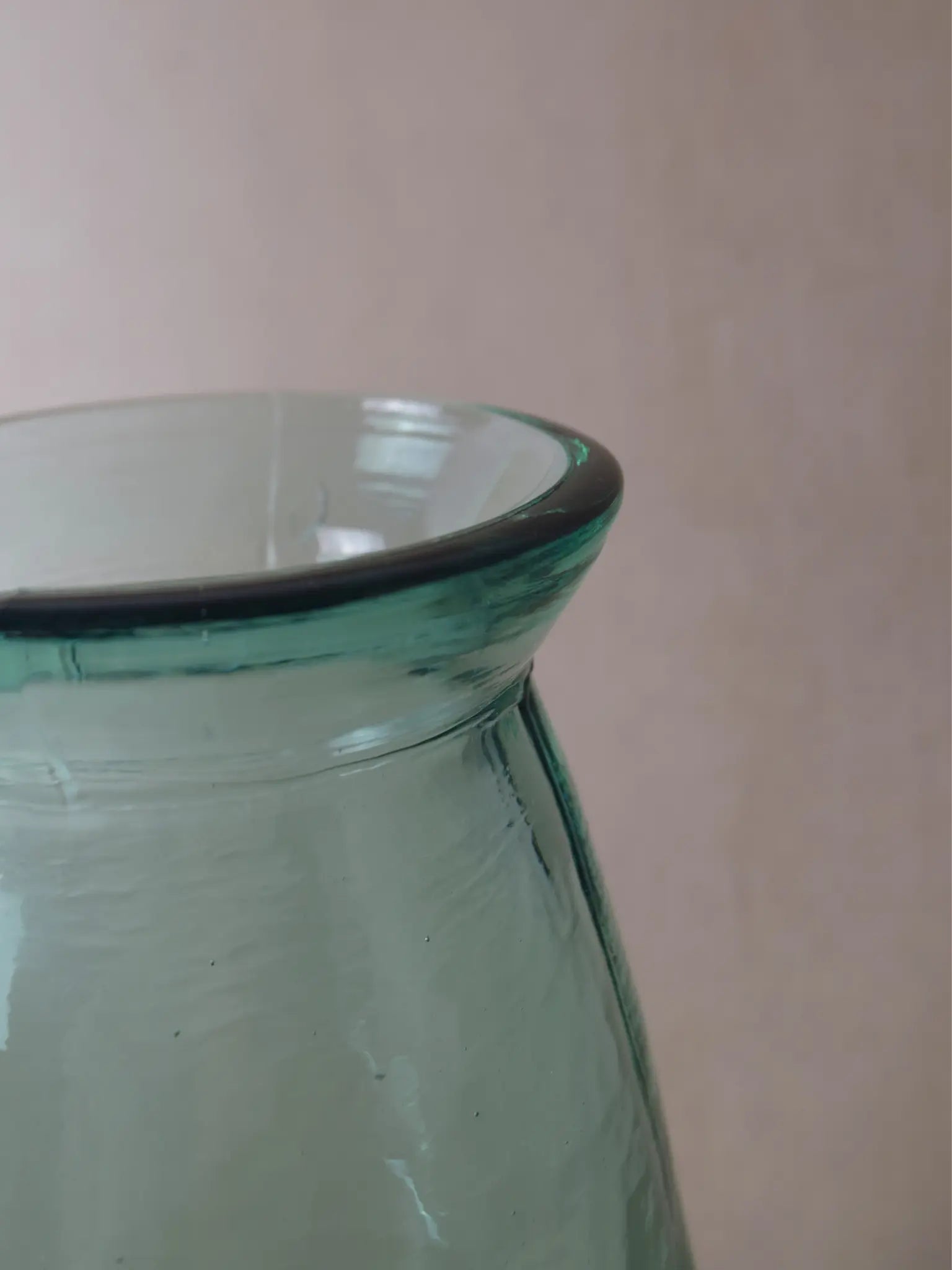 Nahaufnahme einer bläulichen, grossen Vase vor einem beigen Hintergrund