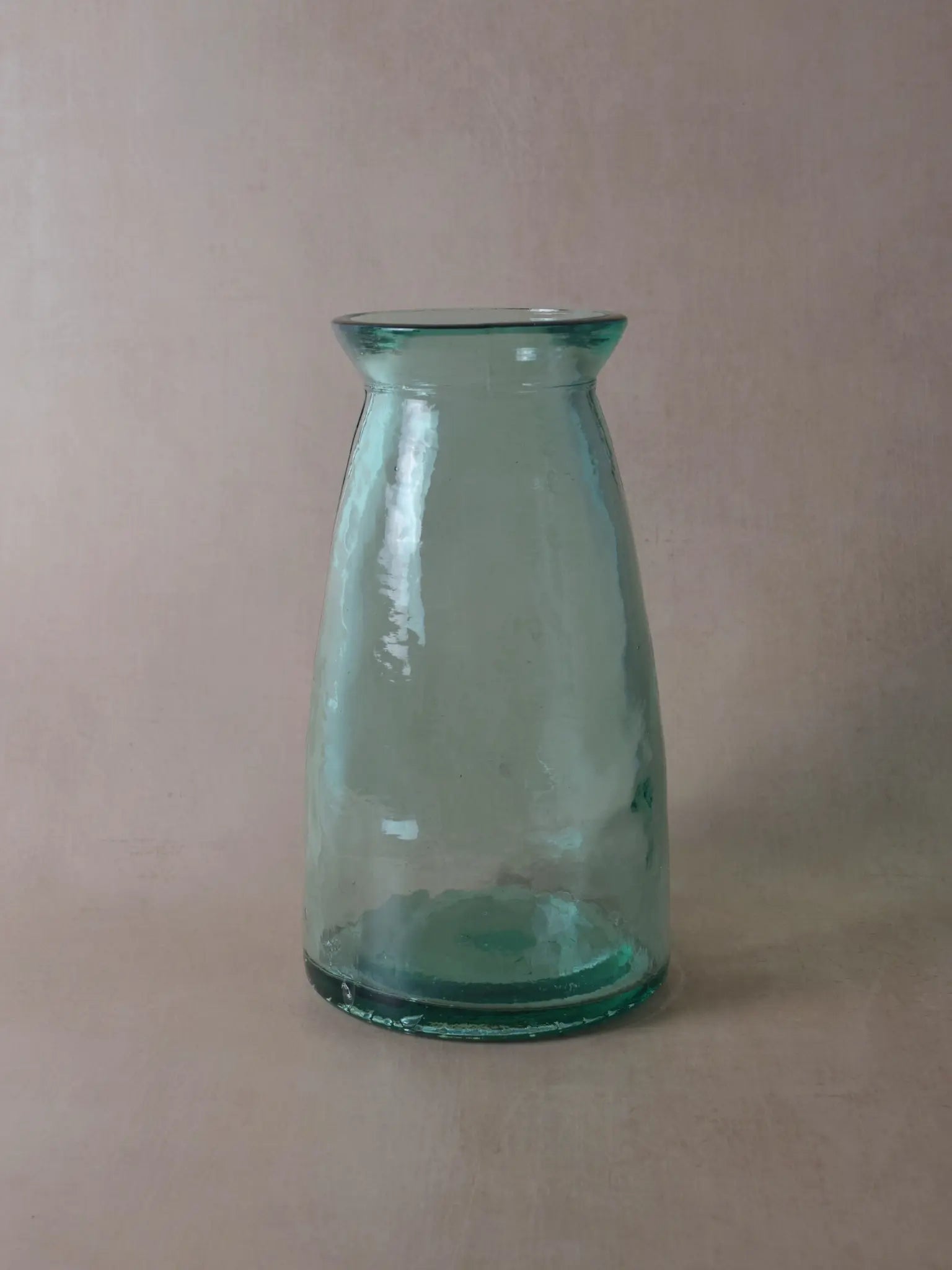 Bläuliche, grosse Vase vor einem beigen Hintergrund